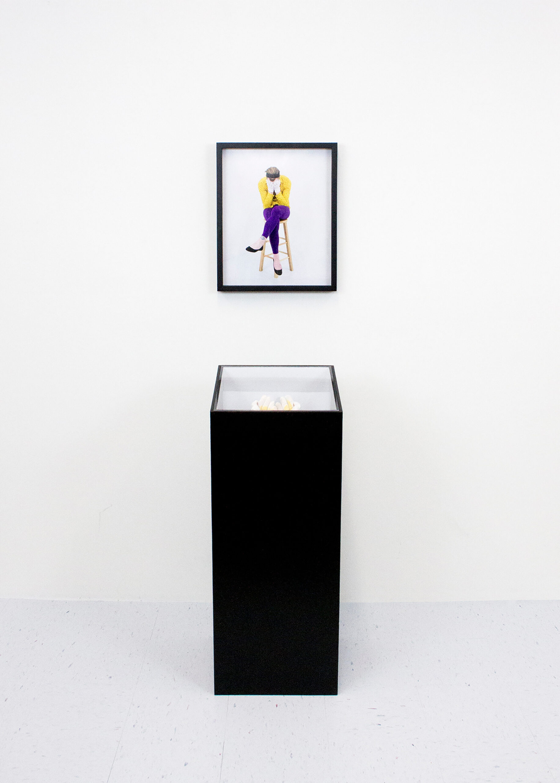Framed photo of the artist and pedestal containing remnants from I'm a Loser performance