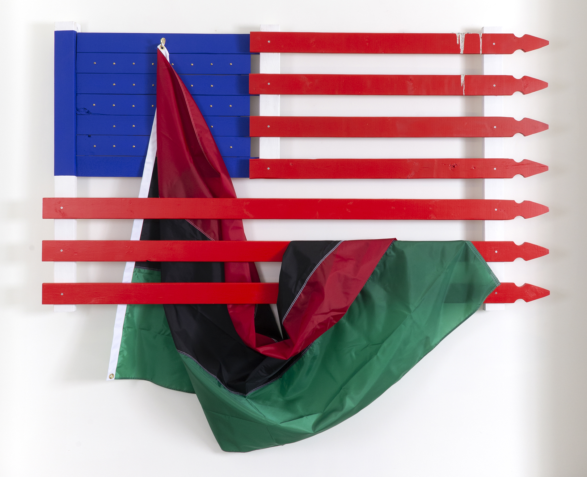 Aaron Coleman's, The Pieta, composed of an American flag made from painted picket fence slats. A pan-African flag hangs from the blue gound and drapes over the lower red stripe slats.