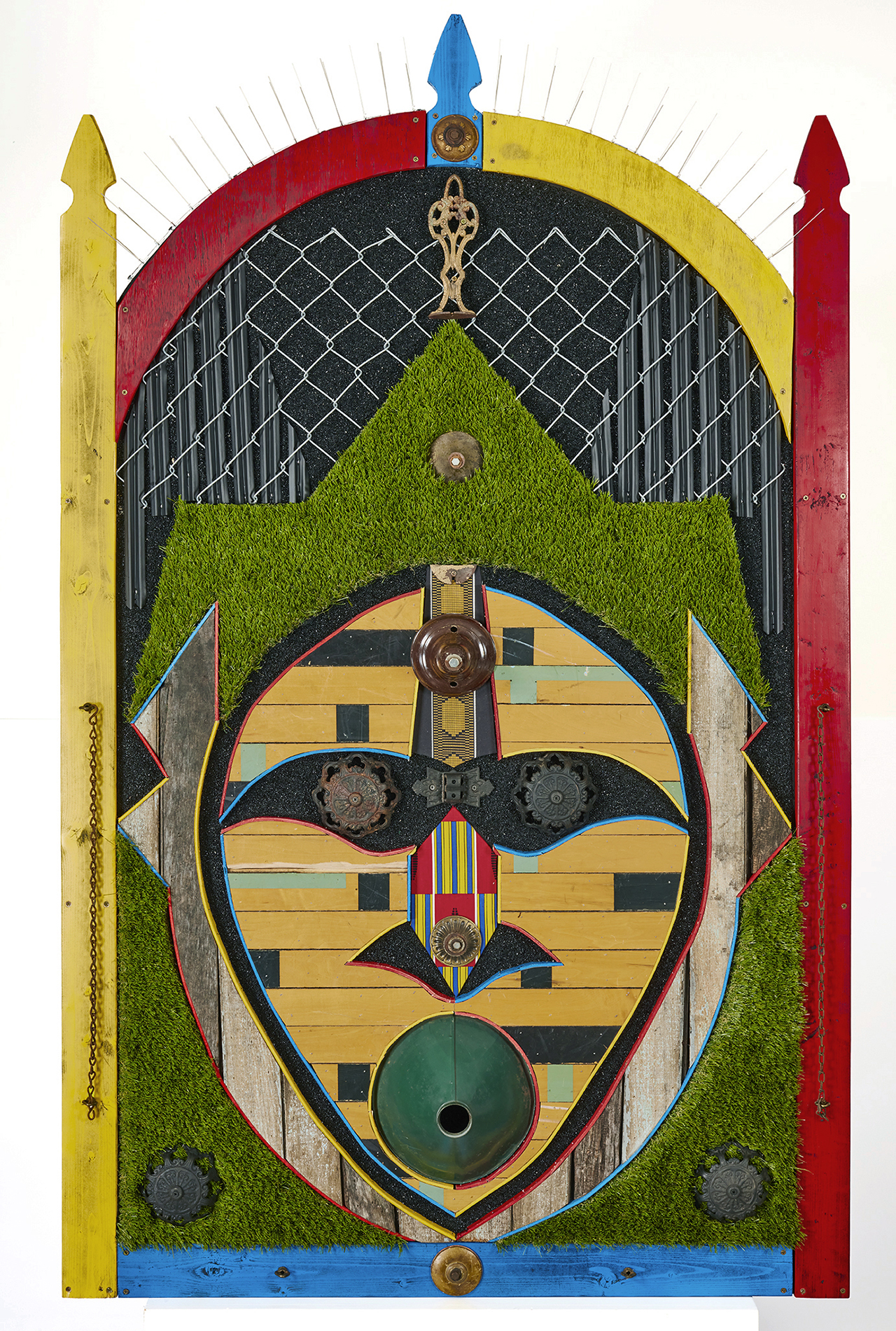 Sentinel, The Spotter; by Aaron Coleman. A mixed media assemblage evoking Ghanaian masks, made from fencing, fake turf, and salvaged wood from a neighbor's home lost to gentrification.