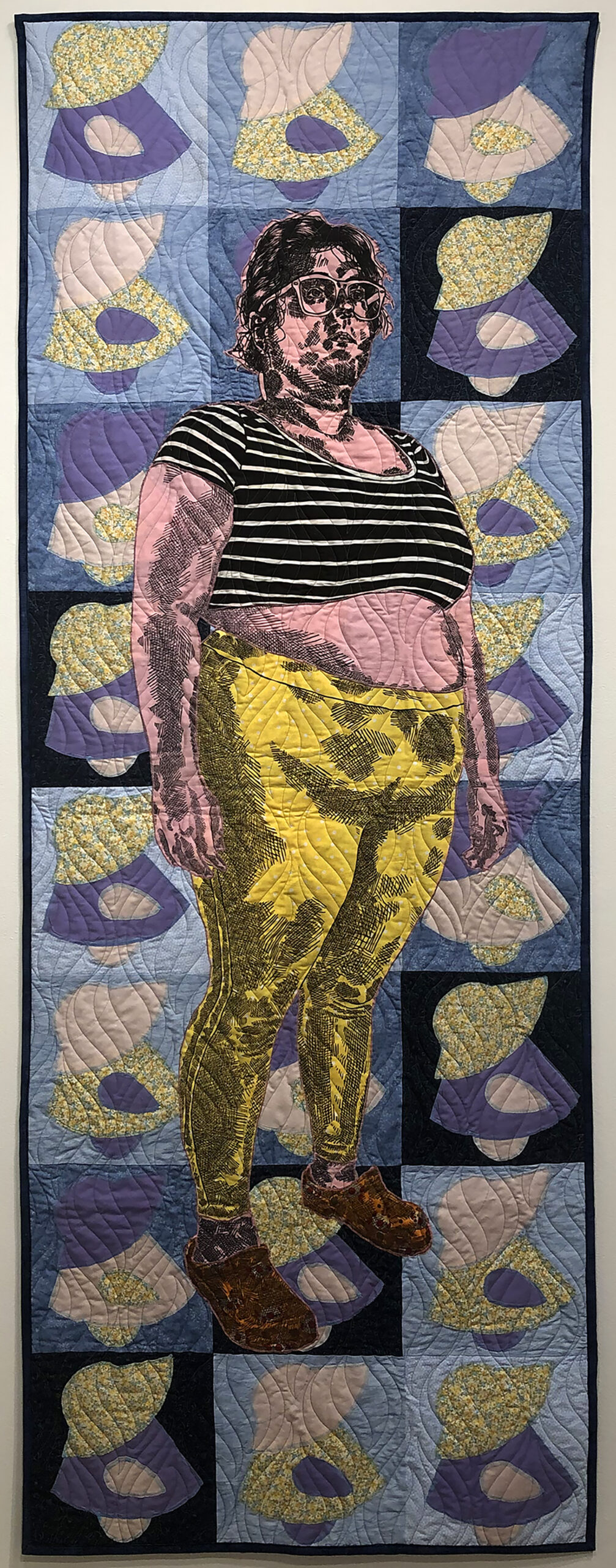 A portrait of the artist relief printed on pink, white, and yellow fabric is stitched upon a "Sunbonnet Sue" quilt.