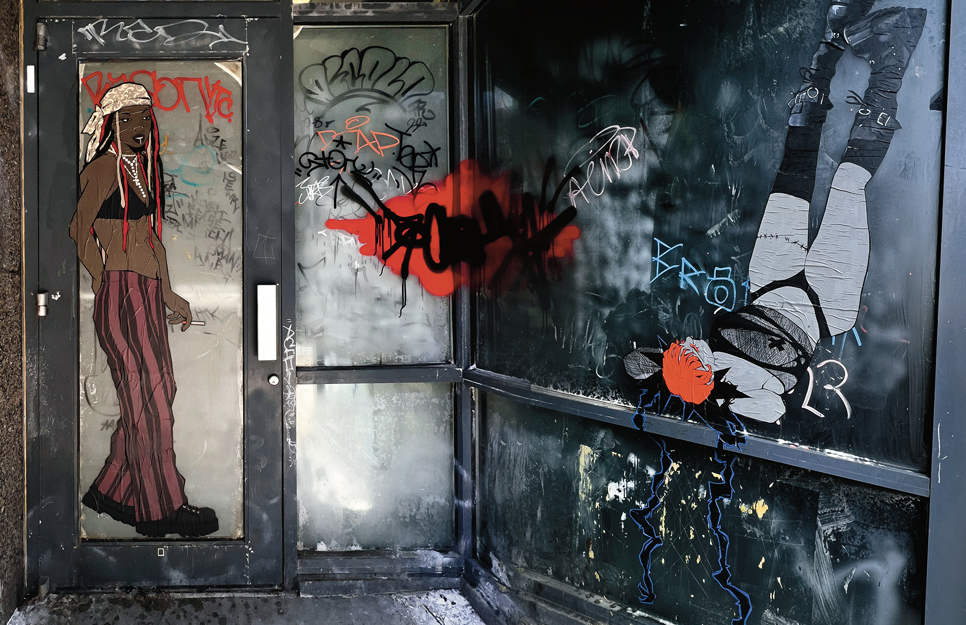 Paste ups of human scale figures in a grafittied doorway. A locced standing figure is smoking on the door, while a second punk figure lays on the adjacent wall with their head in the foreground and their legs in the air as if laying up against the wall.