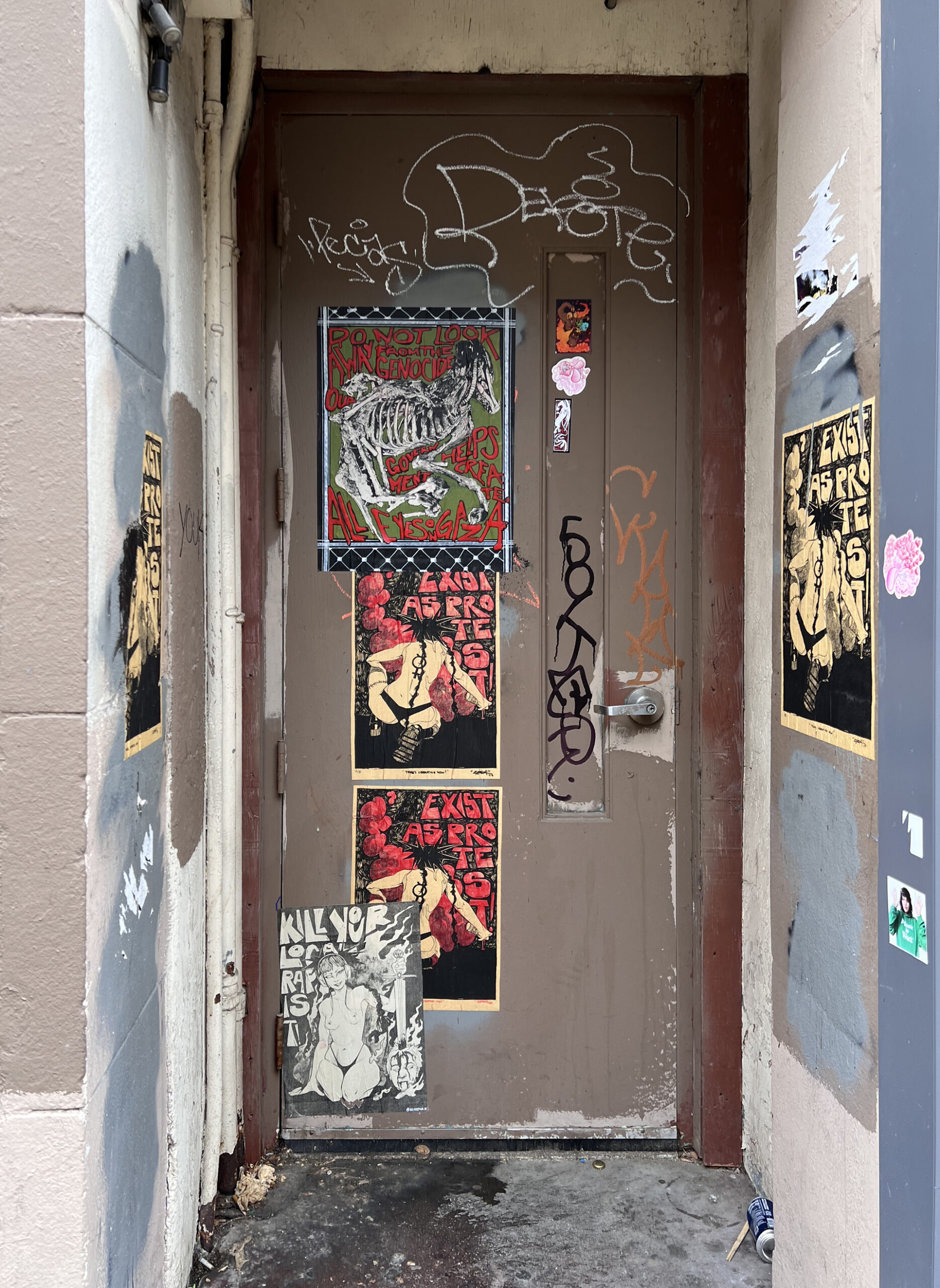 A door way covered in paste ups and other ephemeral artworks by the artist