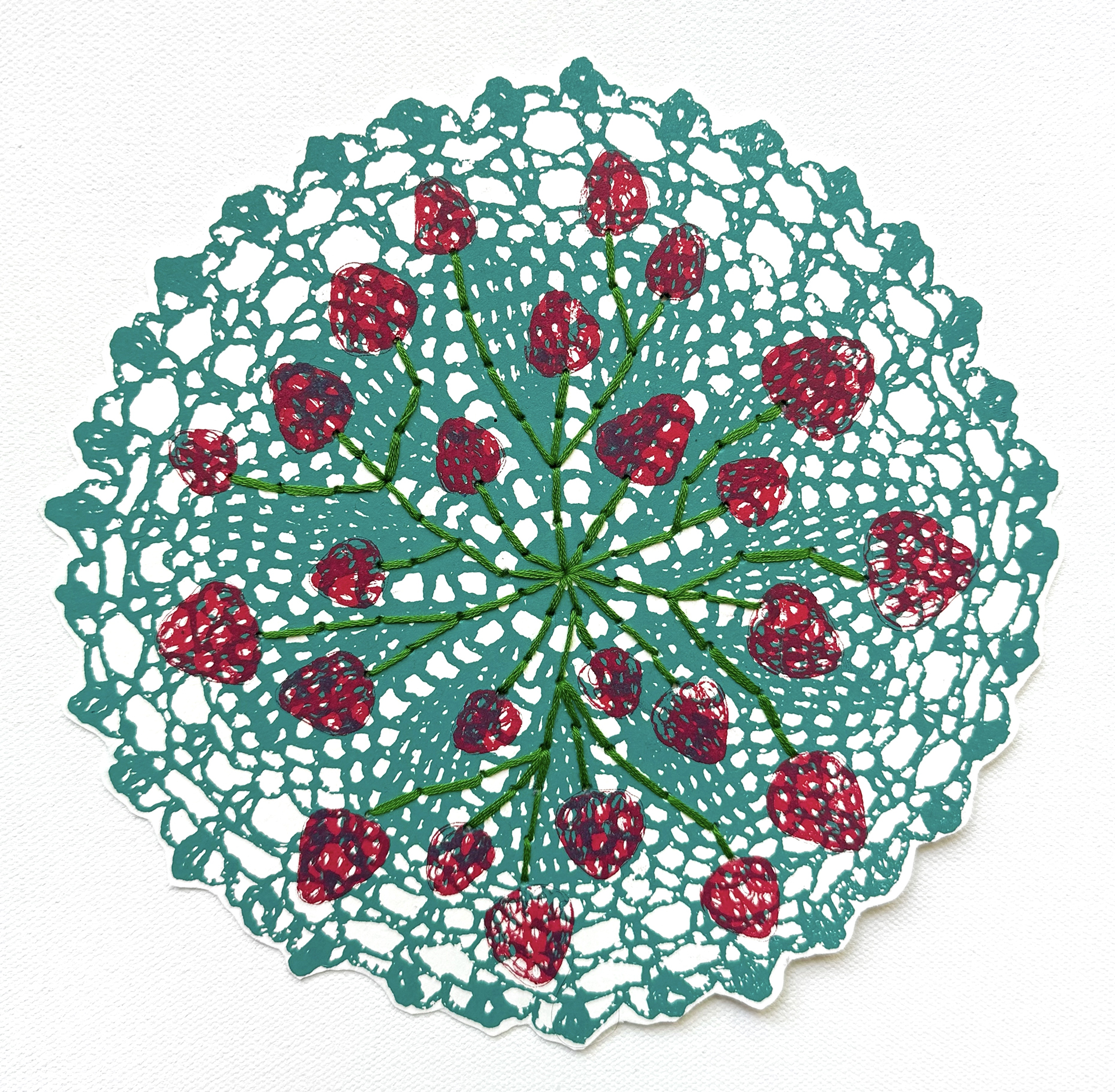 A teal doily is topped by strawberries connected by green embroidered stems.