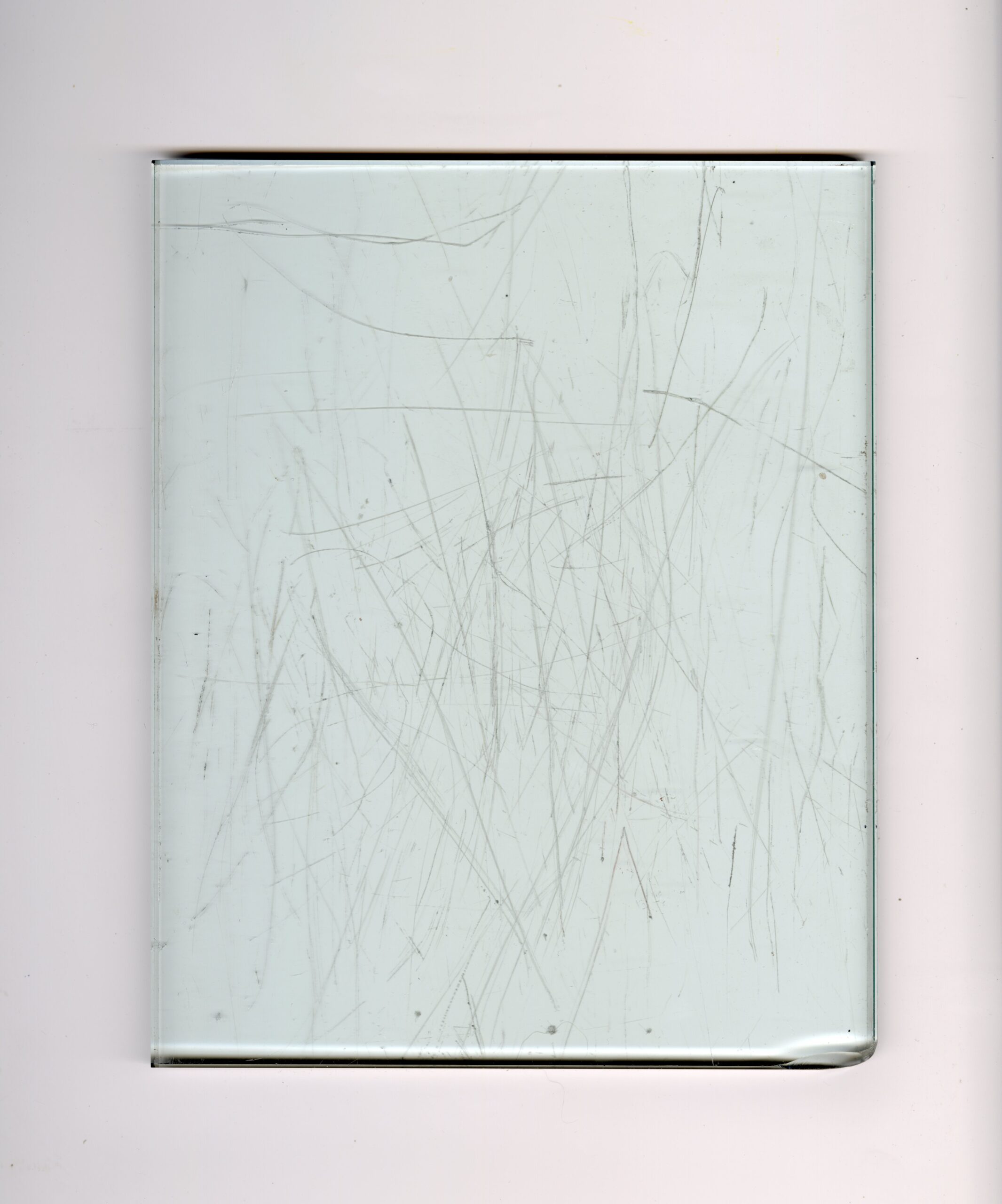 A glass plate covered in scratches the artist used to pull relief monoprints from