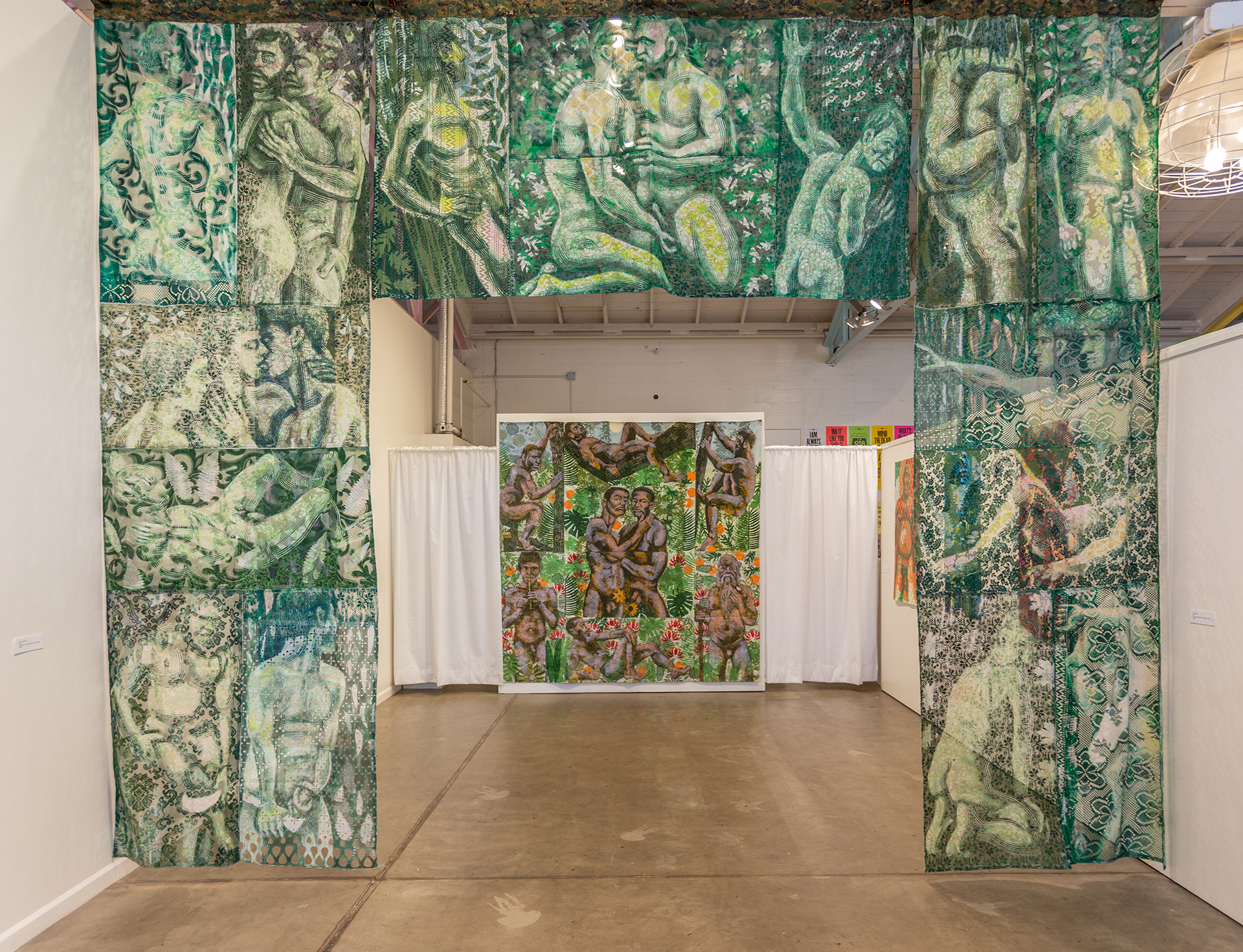 Large scale monoprints on fabric create an entryway of nude men partaking in each other sexually and/or looking out at the viewer to invite or provoke the audience. Beyond the initial archway, a second large, more colorful composition features figures in similar arrangements.