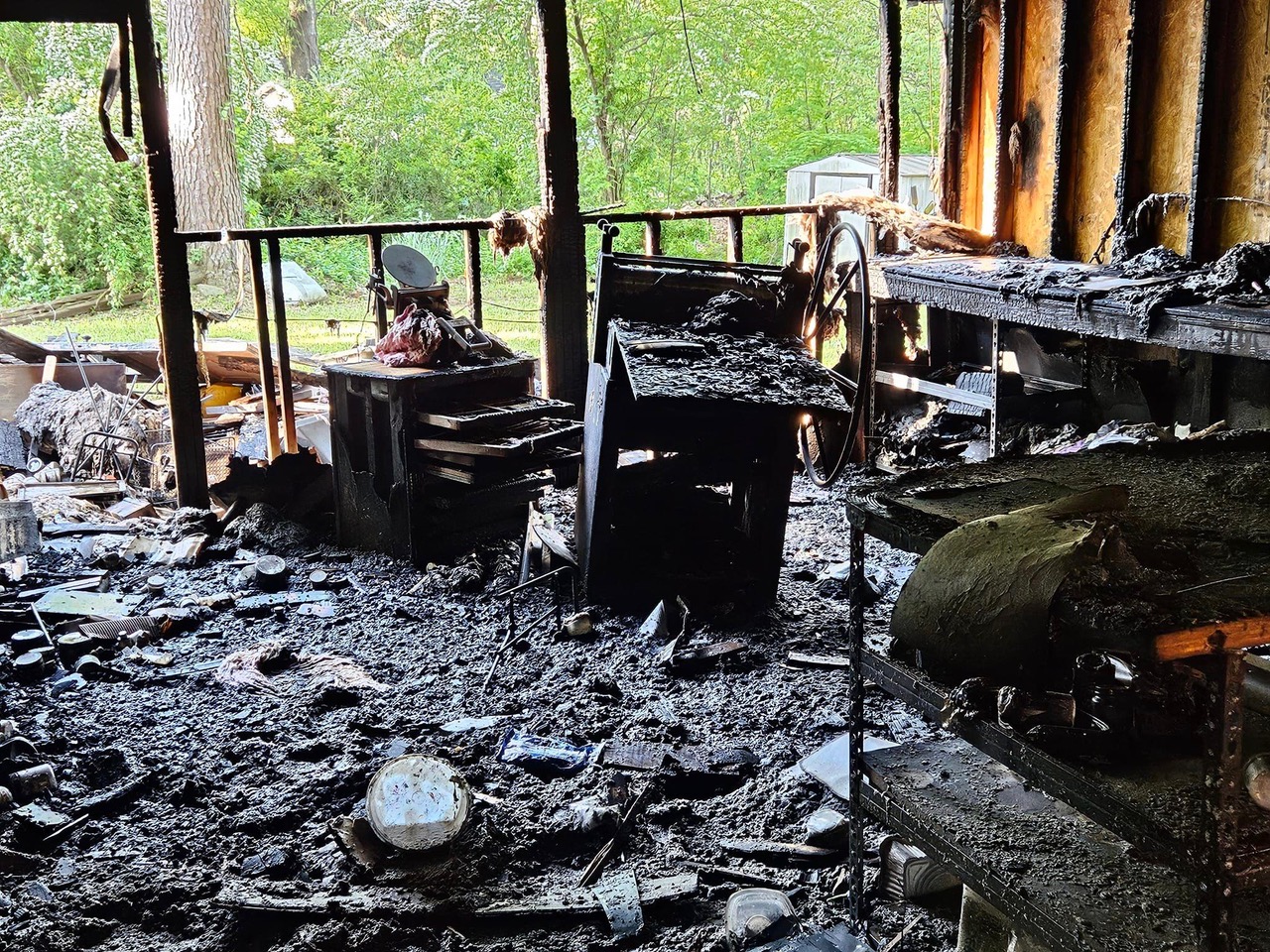 The charred remains of Atabeira Press studio including the etching press and flat file drawers.