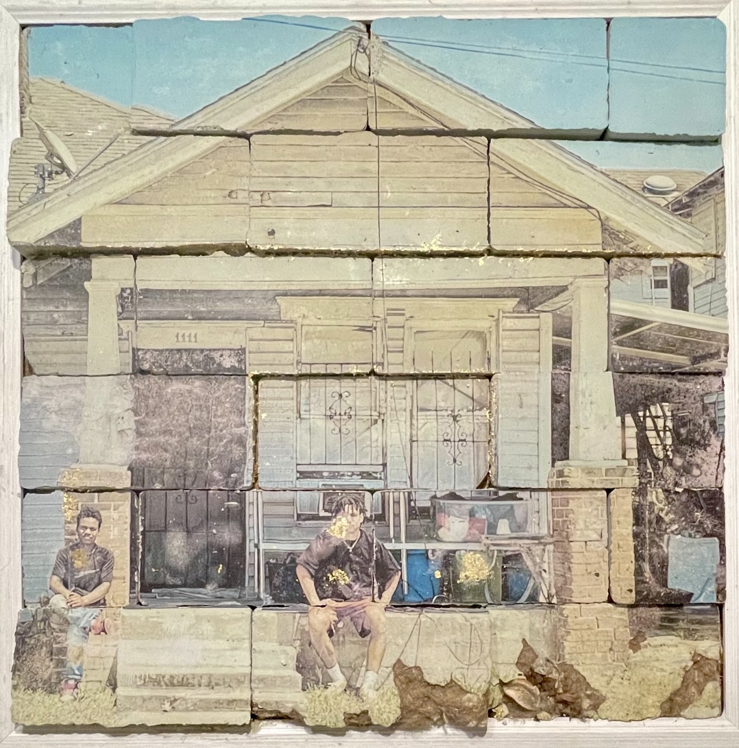 a large photo of two figures sitting on a stoop is transfer printed onto concrete blocks to create a worn, nostalgic aesthetic.