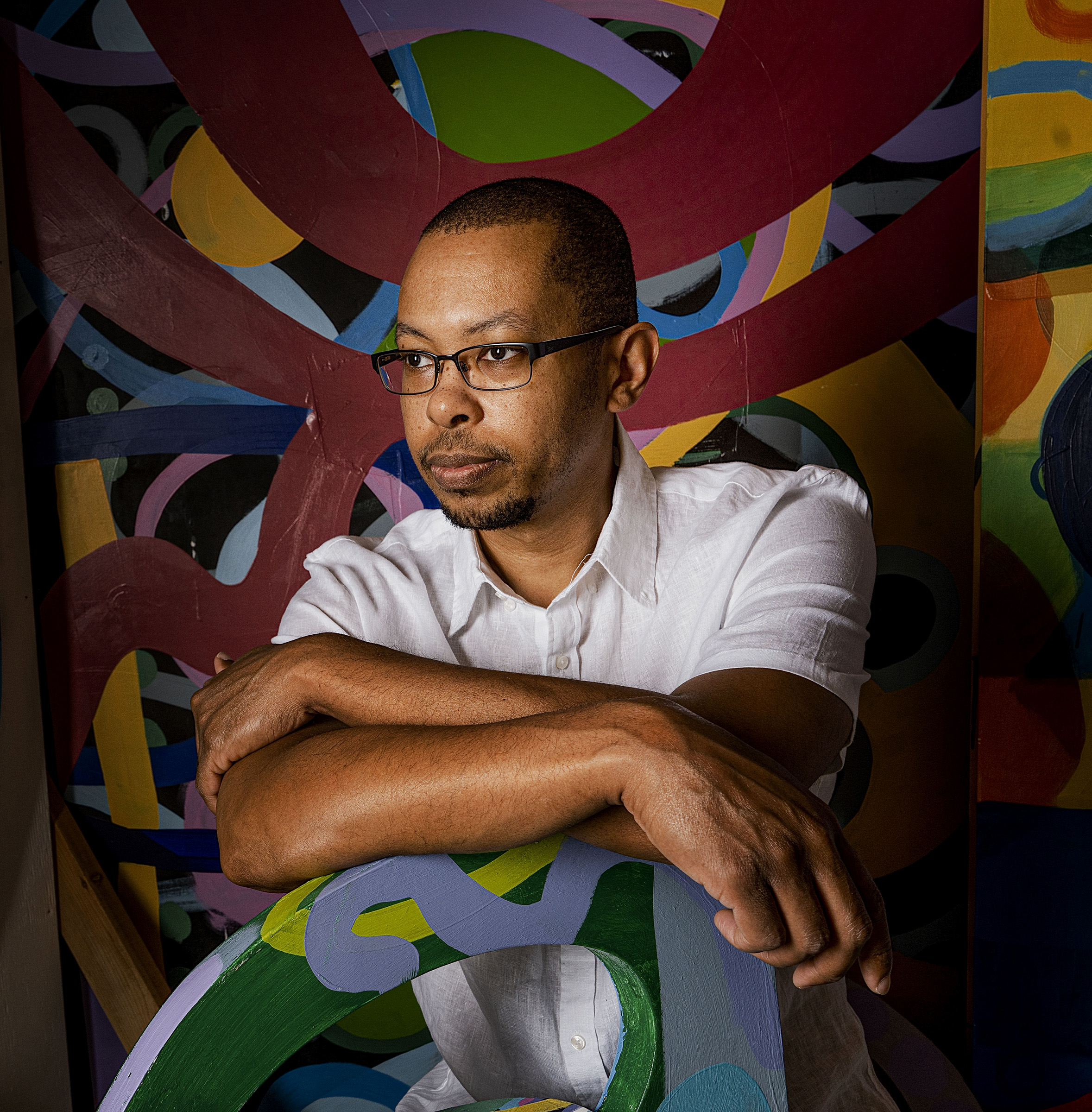 Artist Jamaal Barber in a space filled with bright, abstract acrylic paint.