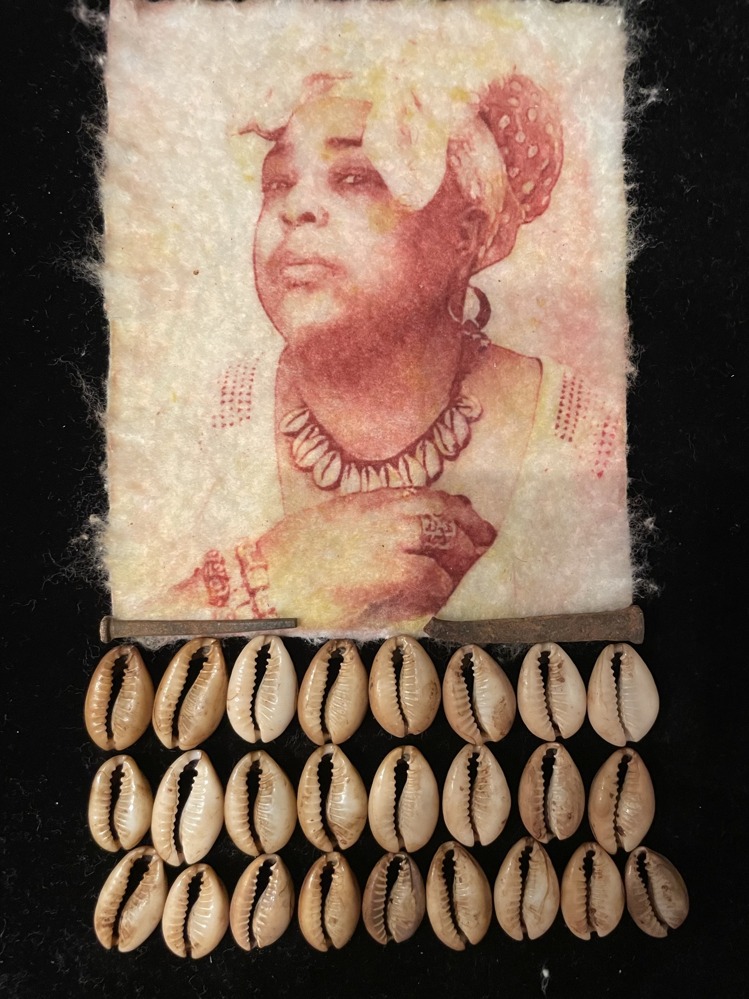 A portrait of the artist in head wrap and cowrie shells is printed on cotton with shells and blacksmith nails beneath.