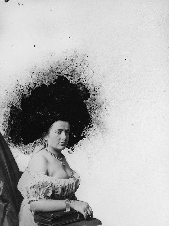 A vintage photo of a seated woman is altered with monoprint and relief to create an enormous coiffure.