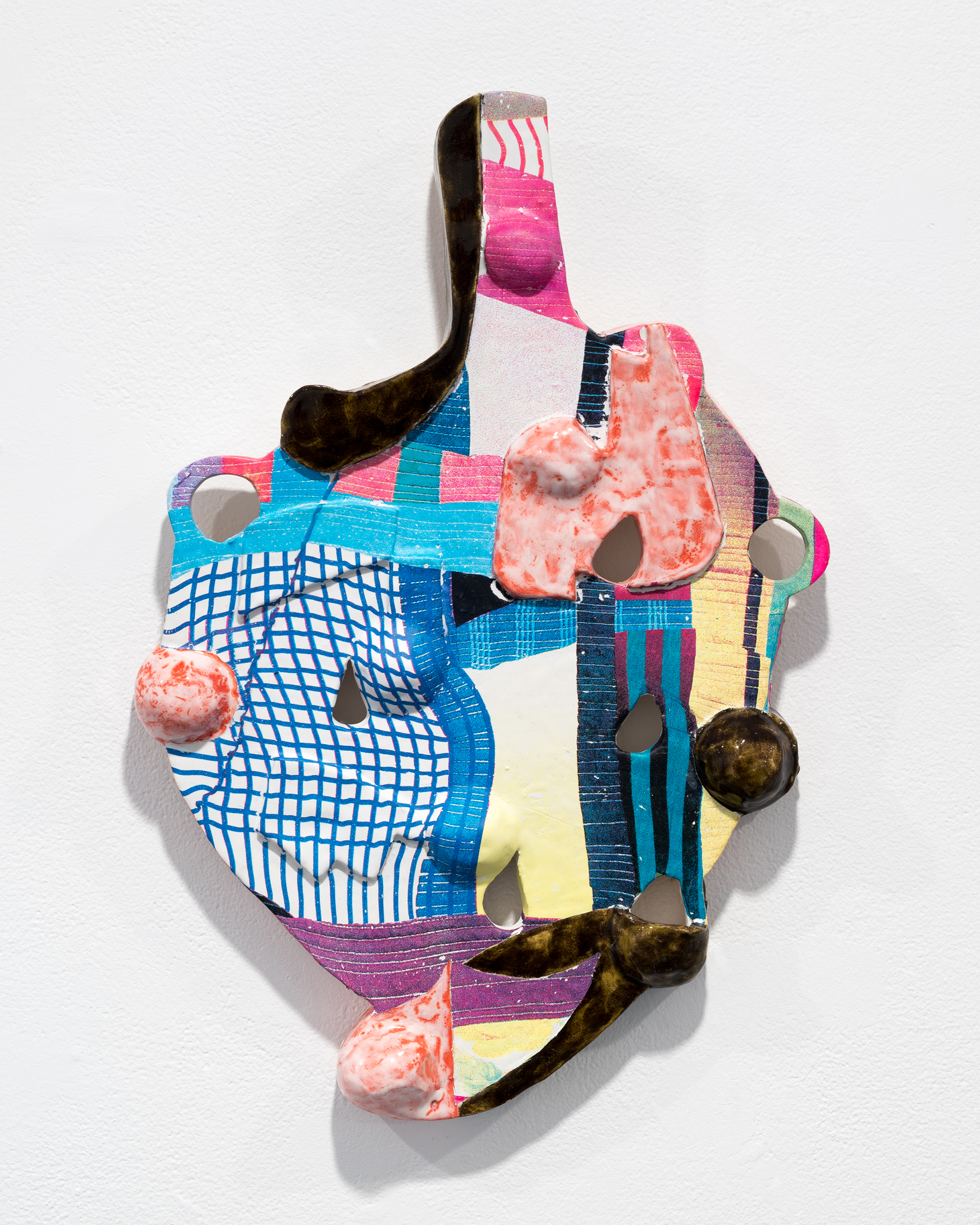 A ceramic wall piece approximating the shape of a heart is covered with varied textures and colors, further abstracting the form.