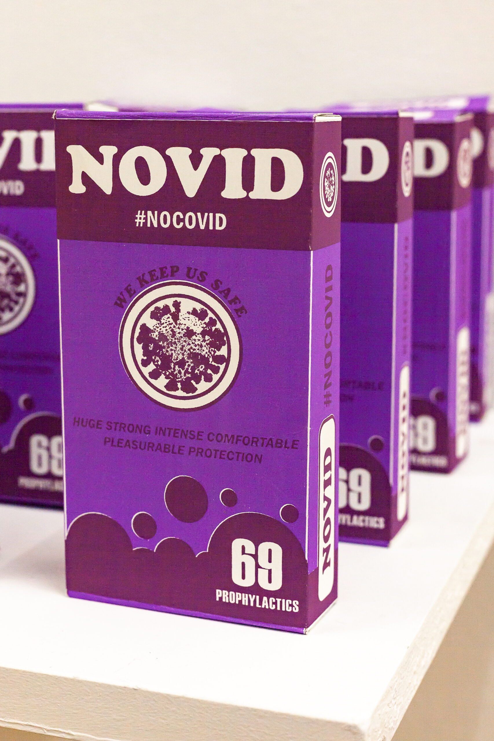 A staggered arrangement of purple boxes of "Novid" prophylactics promoting truly safe sex during the pandemic.