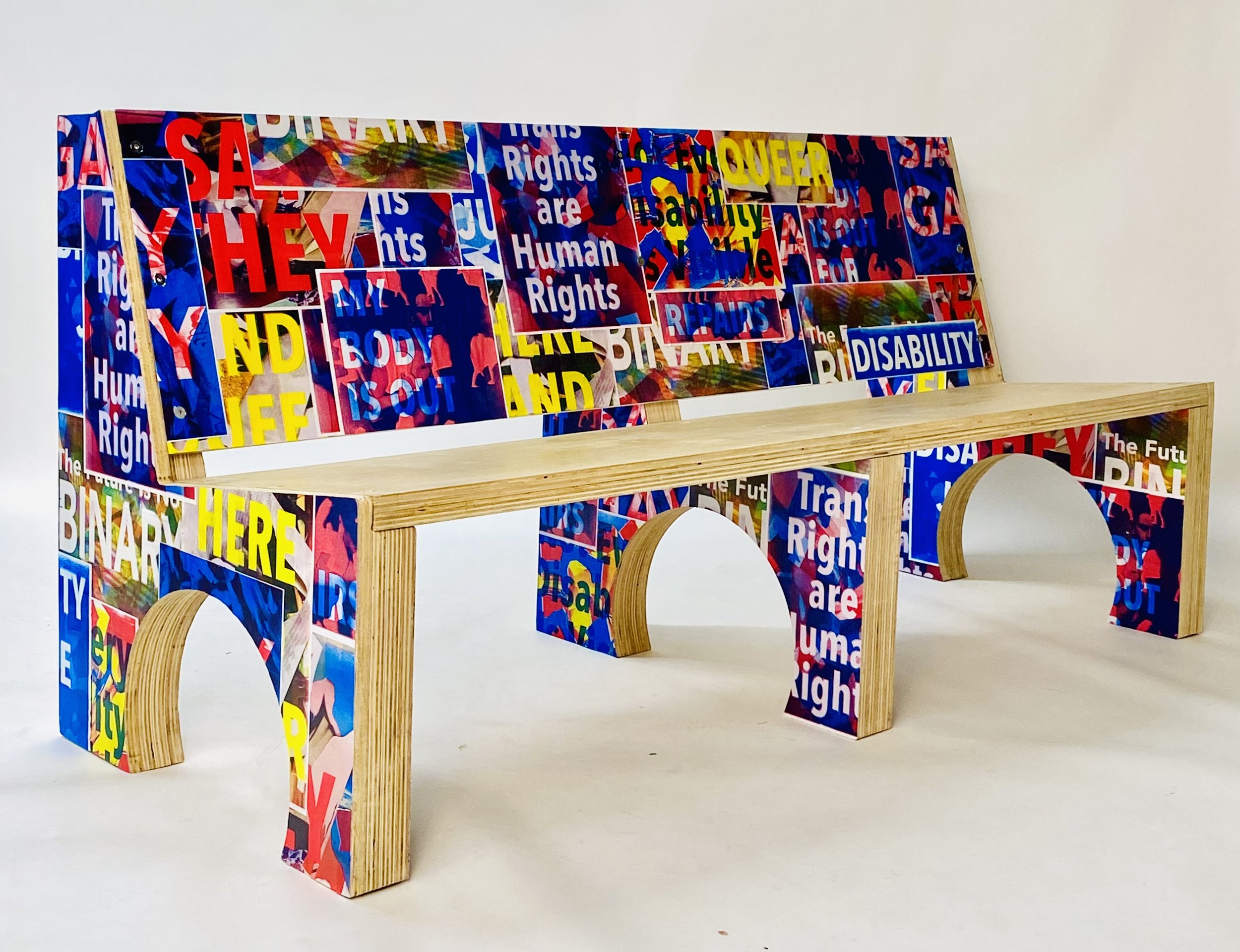 Primary color risograph flyers cover a functional plywood bench.