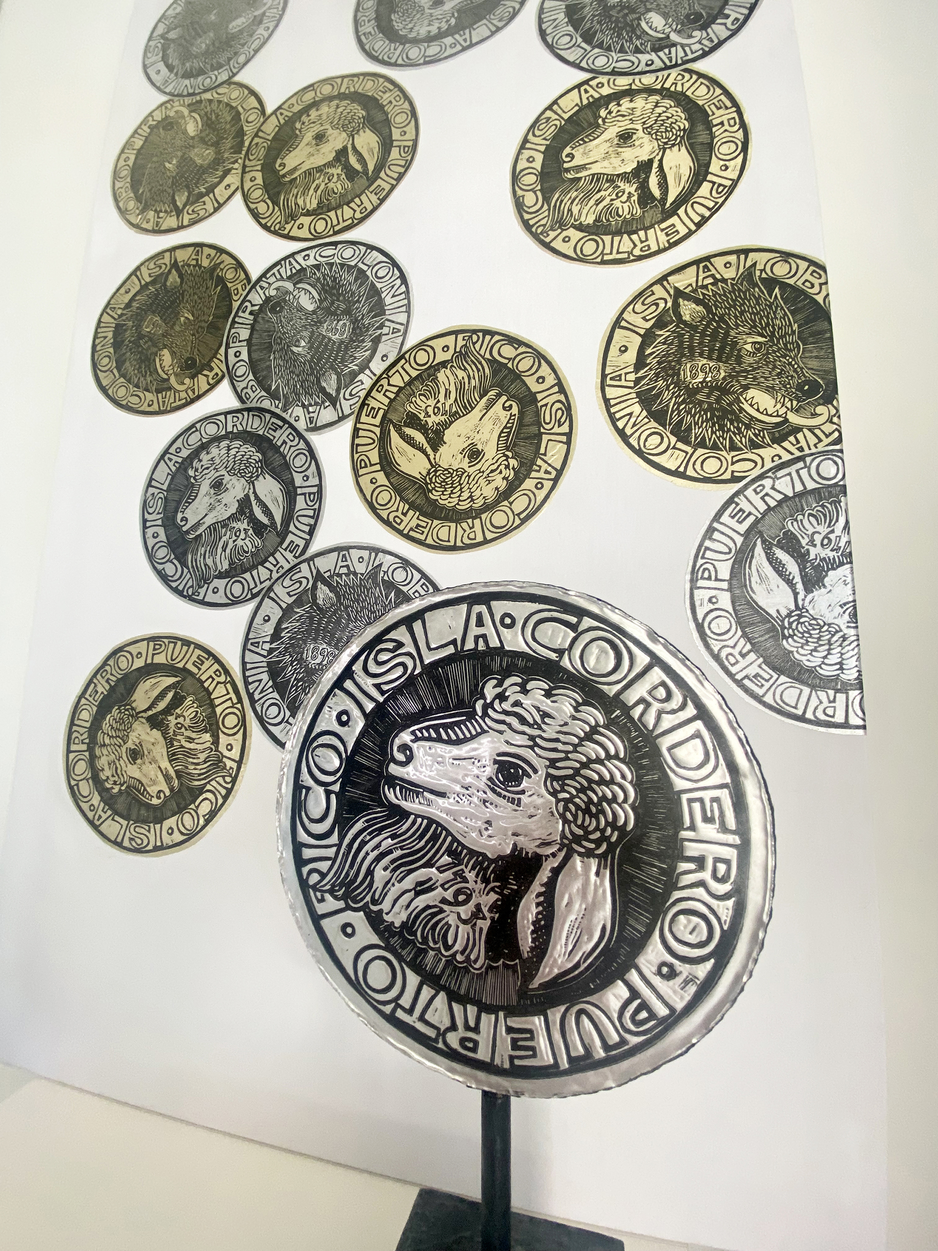 Cascading doubloons in gold and silver feature lambs representing Puerto Rico and wolves representing the colonial powers.