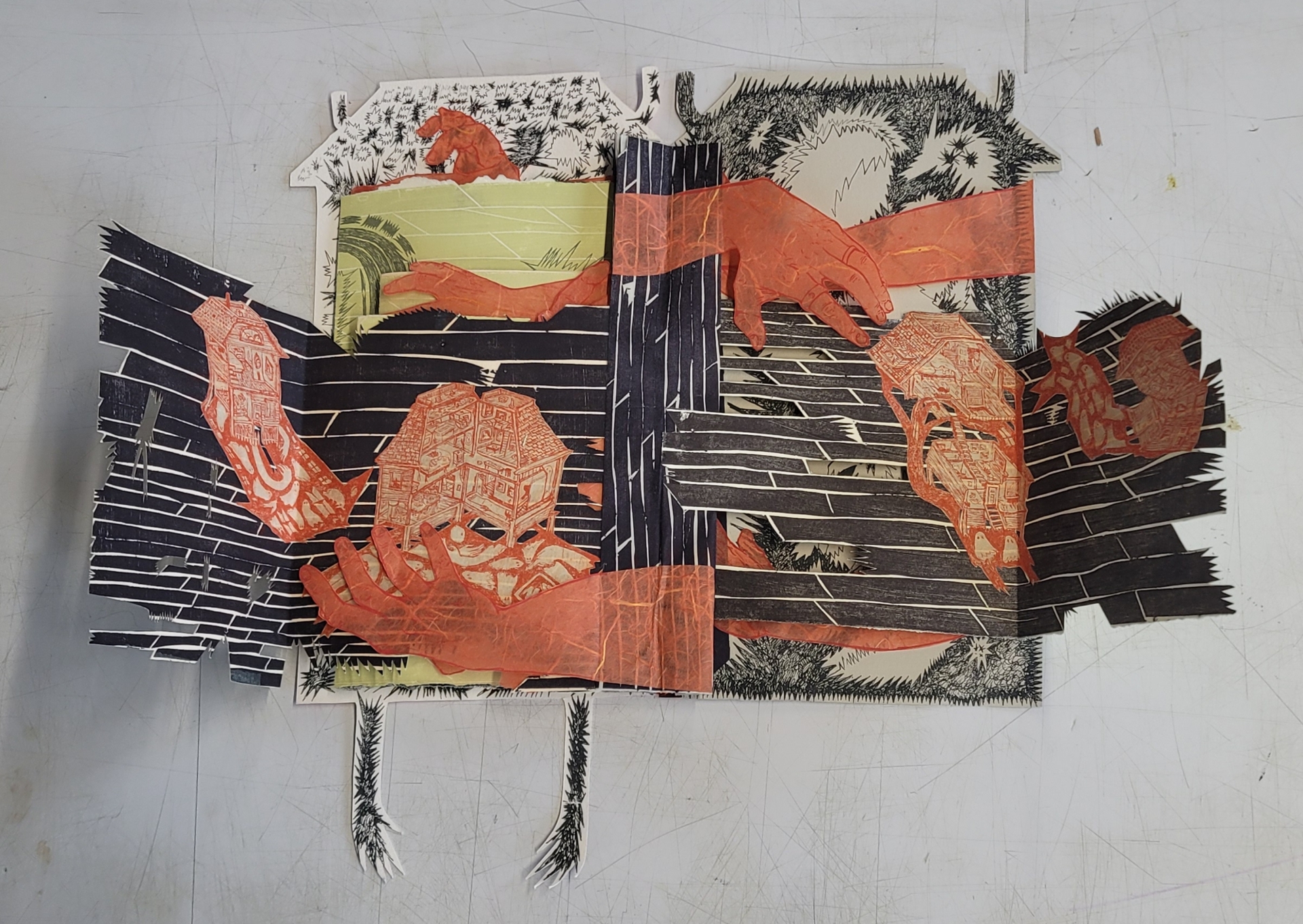 A sprawling artist book evoking a haunted house is filled with varied ghost-like marks and wood textures with red orange hands and fanciful house interiors scatterd about as erratic pages