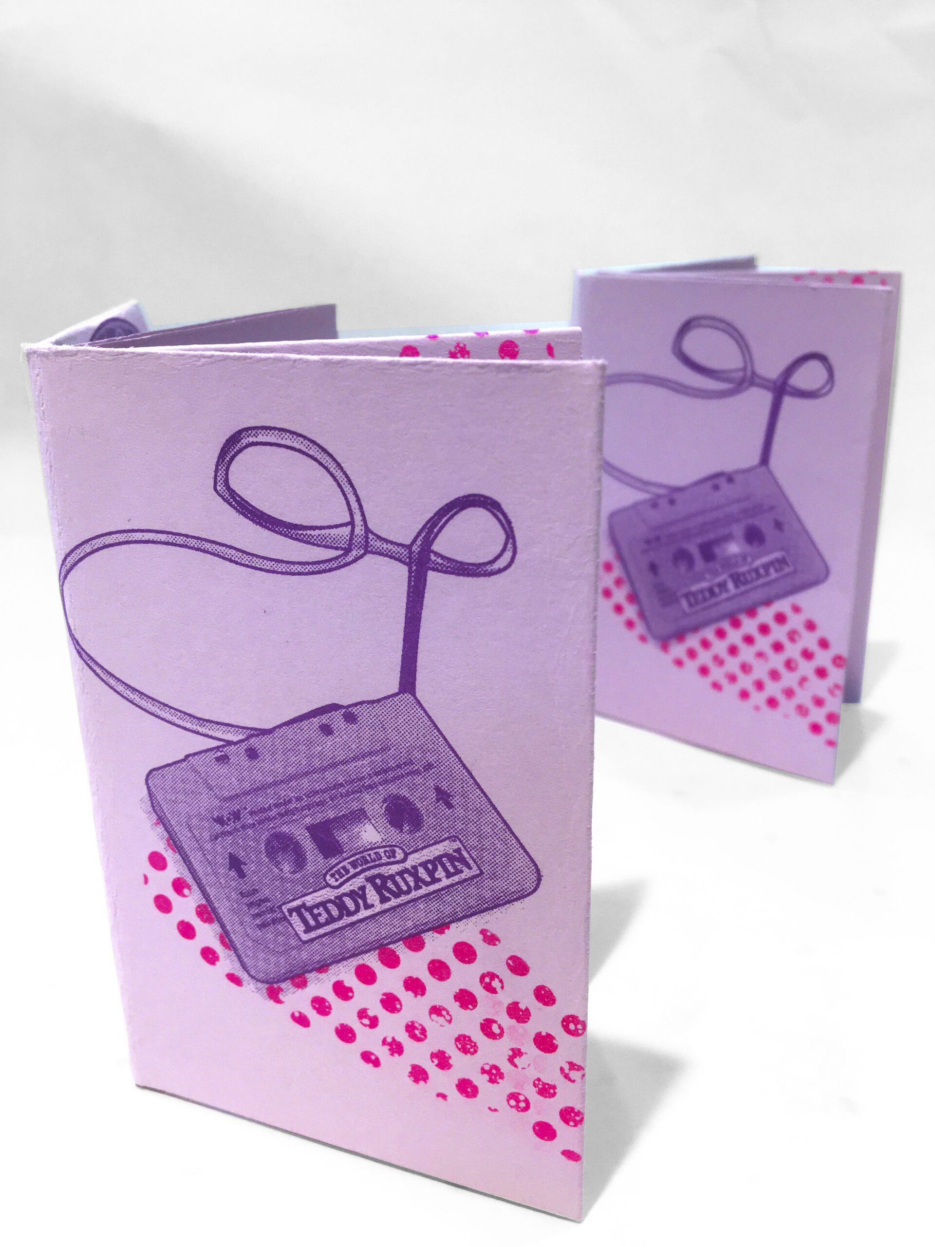 A risograph printed zine depicting a cassette tape from a Teddy Ruxpin doll coming unspooled across the page